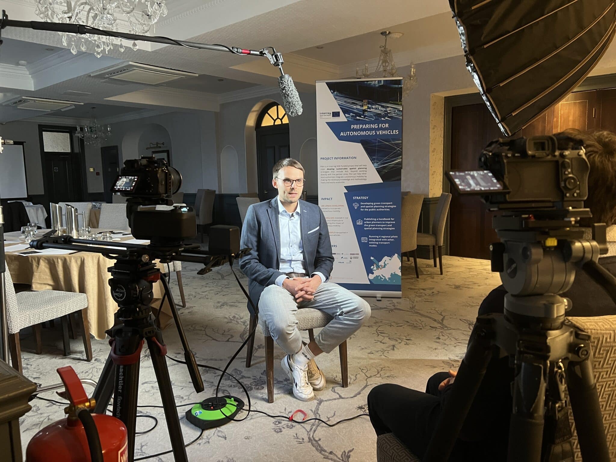 A cheerful businesswoman wearing a headset, working on documents in a modern office setting.
