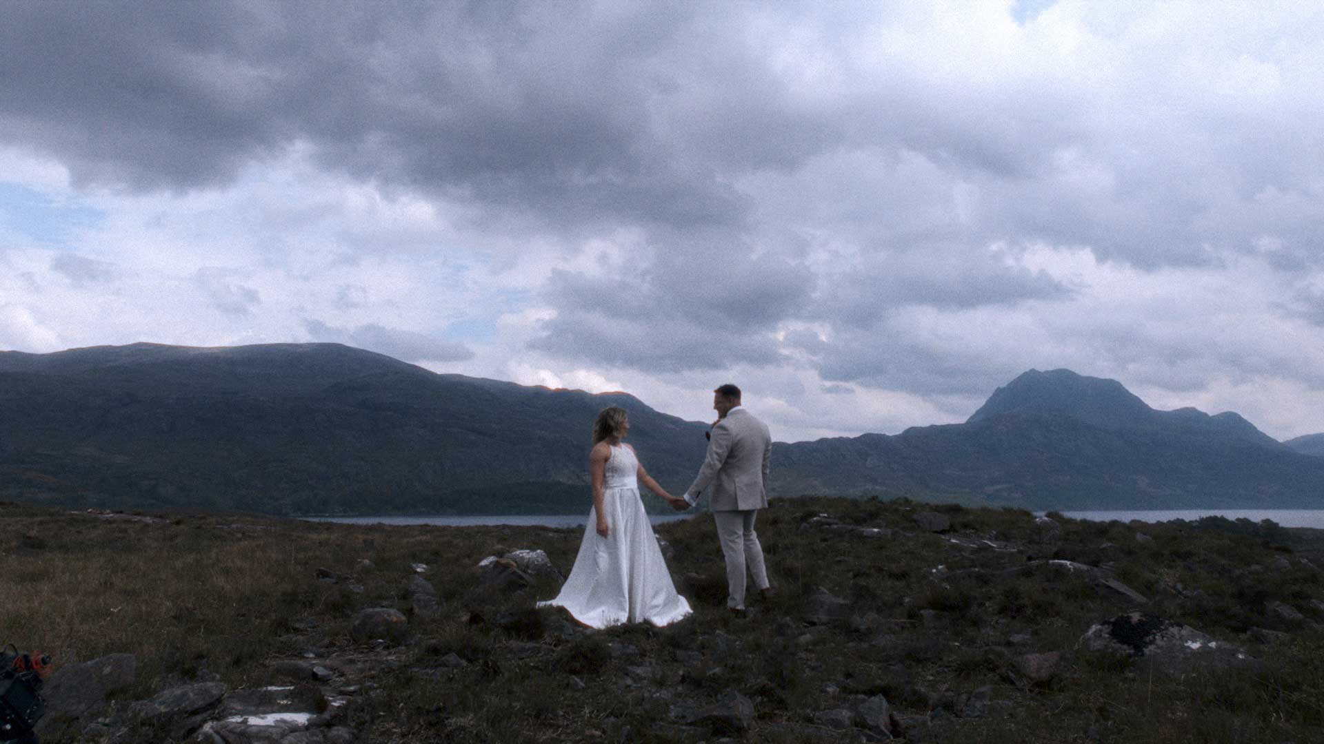 a bride and groom standing on a hill in north of Scotland surrounded by hills and beauty.