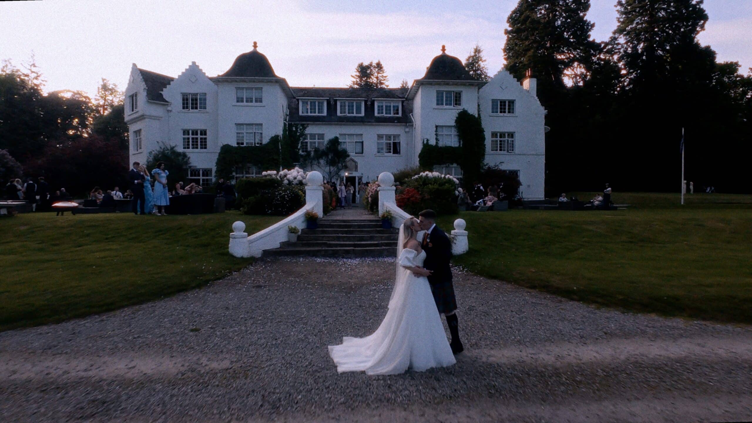Wedding couple kissing in front of Achnagairn Estate wedding venue
